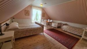 a bedroom with a bed and a table and a window at Lahe Guesthouse in Haapsalu