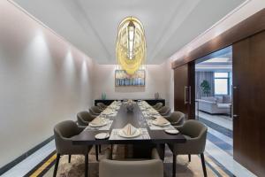 uma sala de jantar com uma mesa longa e cadeiras em Movenpick Hotel and Residences Riyadh em Riade