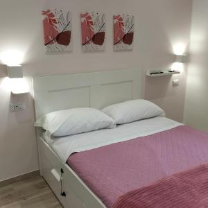 uma cama num quarto com duas pinturas na parede em I 23 PASSI SCAURI em Scauri