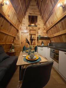 uma cozinha e sala de estar com uma mesa num camarote em Tiny House Ardennes em Fromelennes