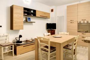uma cozinha e sala de jantar com uma mesa de madeira e cadeiras em Ca ed Giuanoto em Santo Stefano Belbo