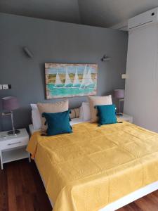 a bedroom with a large yellow bed with blue pillows at Explora Prestige in Blue Bay