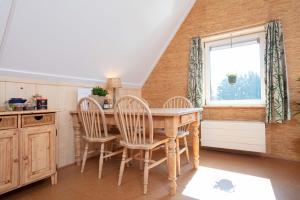 a kitchen with a table and chairs and a window at Vegan B&B De Groene Mus in Wervershoof