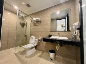Grand Dragon Noi Bai Hotel في هانوي: حمام مع مرحاض ومغسلة ودش