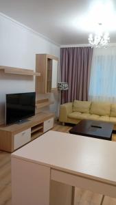 a living room with a couch and a table at MARCY APARTAMENT in Bucharest