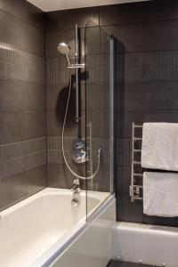 a bathroom with a shower and a bath tub at George Albert Hotel & Spa in Dorchester