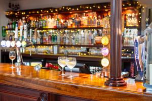 a bar with two wine glasses on the counter at George Albert Hotel & Spa in Dorchester