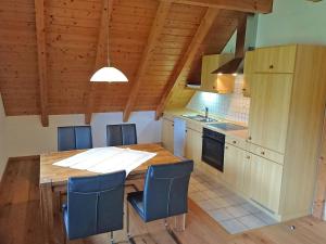 eine Küche mit einem Holztisch und blauen Stühlen in der Unterkunft Hermeshof und Biohaus in Titisee-Neustadt