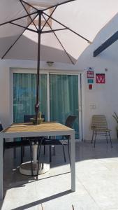 - une table avec un parasol dans l'établissement Corralejo Suite Pool & Gardens - Alisios Playa, à Corralejo