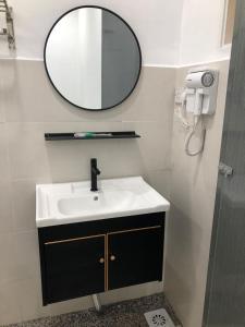 een badkamer met een wastafel en een spiegel aan de muur bij SAMMY HOOMESTAY in Ipoh