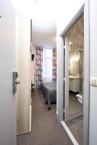 Cette chambre comprend un lit et une salle de bains pourvue d'un miroir. dans l'établissement Hotel Derby MERODE, à Bruxelles