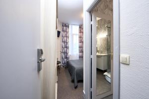 ブリュッセルにあるHotel Derby MERODEのベッド1台とバスルームが備わる小さな客室です。