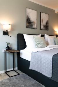 - une chambre avec un lit et une table de chevet dans l'établissement QT Apartments Detmold, à Detmold