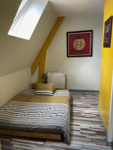 a bedroom with a bed in a attic at La Grange du Pont in Civray-de-Touraine