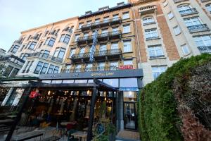 ein großes Gebäude mit einem Restaurant davor in der Unterkunft Hotel Derby MERODE in Brüssel