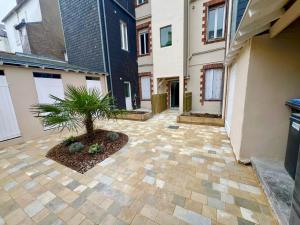a courtyard with a palm tree in the middle of a building at Appartsaintnazaire - Saint Nazaire - 5 Appartements - Centre Ville in Saint-Nazaire