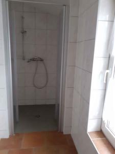 Camera con piastrelle bianche e bagno con doccia. di Apartment in Pruchten 41178 a Pruchten