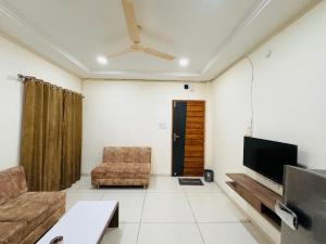 a living room with a couch and a flat screen tv at Home Escape 1BHK Apartment Near Bombay Hospital in Indore