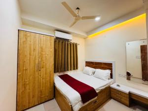 a bedroom with a large bed and a mirror at Home Escape 1BHK Apartment Near Bombay Hospital in Indore