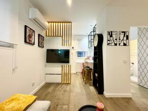 ein Wohnzimmer mit einem Flachbild-TV an der Wand in der Unterkunft Luxury private Flat City Center, AC & Parking gratuito in Madrid