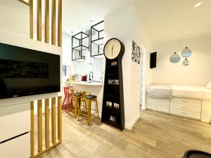 un soggiorno con orologio e una camera da letto di Luxury private Flat City Center, AC & Parking gratuito a Madrid