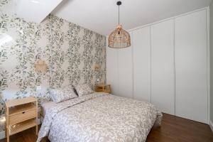 1 dormitorio con cama y papel pintado con motivos florales en From Madrid with Love, en Madrid