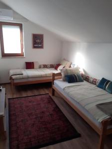 a living room with two beds and a rug at Home away from home in Ilidža