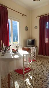 un comedor con una mesa blanca y cortinas rojas en O'GERA Greek resort house in the mountains, 