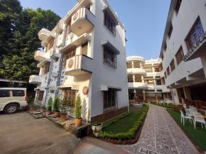 a white building with potted plants in front of it at Hotel Kolam in Shānti Niketan