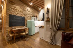 a kitchen with a table and a chalkboard on a brick wall at Al 24 Rosso in Siena