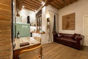 ein Wohnzimmer mit einem Ledersofa und einem Tisch in der Unterkunft Al 24 Rosso in Siena