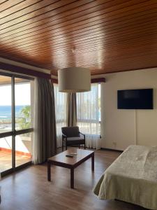 - une chambre avec un lit, une table et une chaise dans l'établissement Flag Hotel Madeira - Ribeira Brava, à Ribeira Brava