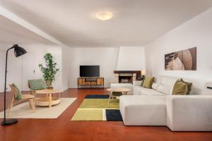 ein Wohnzimmer mit einem weißen Sofa und einem TV in der Unterkunft Casa da Azenha - Quinta do Boição - Private pool in Bucelas