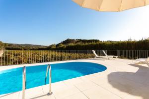 einen Pool mit 2 Stühlen und einem Sonnenschirm in der Unterkunft Casa da Azenha - Quinta do Boição - Private pool in Bucelas