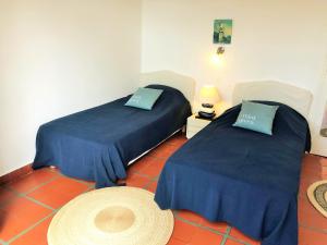 2 Betten mit blauer Bettwäsche in einem Zimmer in der Unterkunft PINSONS maison familiale proche plage in Pyla-sur-Mer