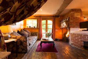 a living room with a couch and a fireplace at The Bakery a honeymooners favourite cosy stylish with lovely walks and pubs 