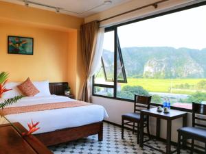 a hotel room with a bed and a large window at Tam Coc Lion Kings Hotel & Resort in Ninh Binh
