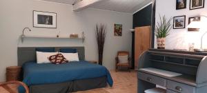 a bedroom with a blue bed and a dresser at Au Logis de la Mongie in Soullans +56 photos