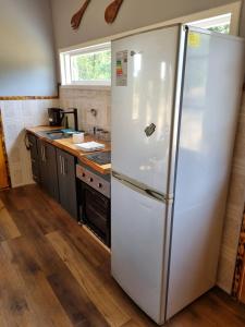 a white refrigerator in a kitchen with a counter at Cabaña en carretera 5 sur y granja de animales in La Paz