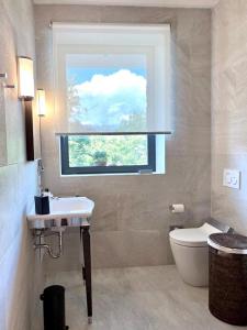a bathroom with a window and a sink and a toilet at The Iconic Lodge in Bellagio