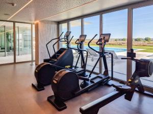 a gym with treadmills and ellipticals in a building at Bayline Condominium - Heated indoor Swimming pool - SPA - By Bedzy in Armação de Pêra