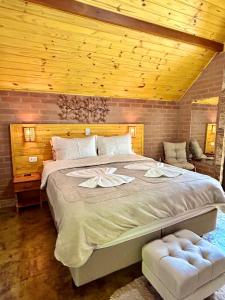 a bedroom with a large bed with a wooden ceiling at Pousada Verdes Alpes in Santo Antônio do Pinhal