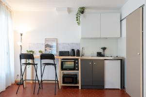 a kitchen with two chairs and a counter with a sink at Superbe studio cosy et calme in Digne-les-Bains