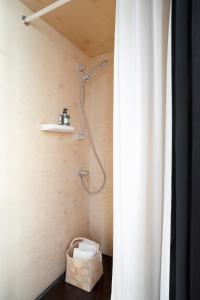 a bathroom with a shower and a basket of towels at Majamaja Helsinki off-grid retreat in Helsinki