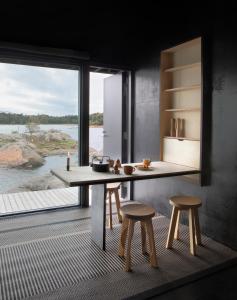 a kitchen with a table and two stools and a large window at Majamaja Helsinki off-grid retreat in Helsinki