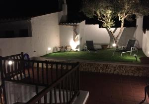 a house with two chairs and a yard at night at Hotel Es Mercadal in Es Mercadal