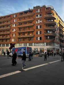 people walking in the street in front of a building at Meraki Family House in Naples