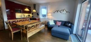 ein Wohnzimmer mit einem Tisch und einem blauen Sofa in der Unterkunft Dachsteinblick by Alpendyll Apartments in Haus im Ennstal
