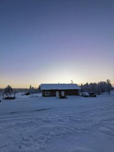 een huis in een veld bedekt met sneeuw bij Majoitus Valkea in Nunnanen