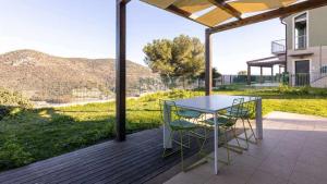 a patio with a table and chairs on a deck at PiscinaParkingVista Mare La Perla Ligure AC in Pietra Ligure